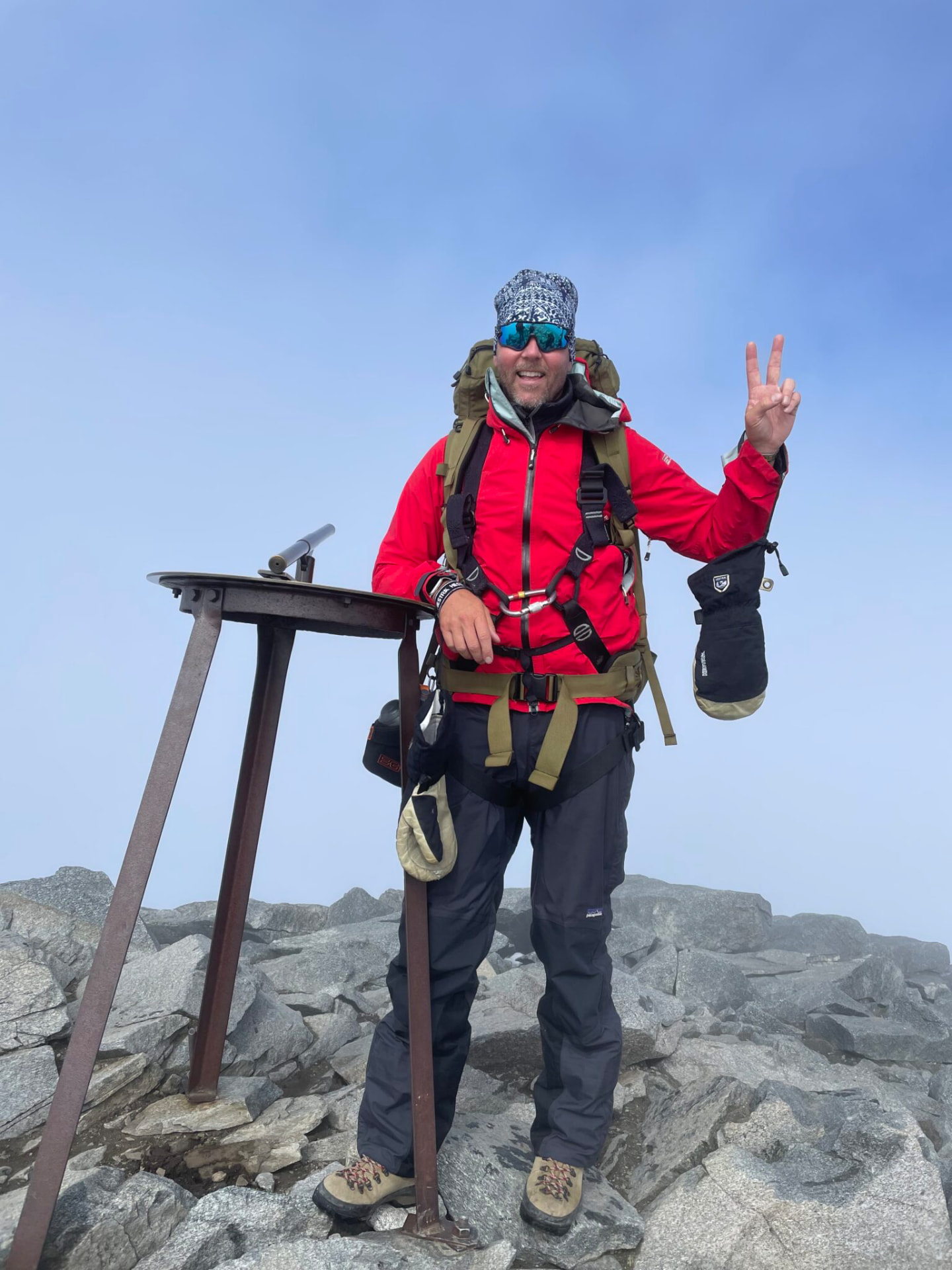 John Björksten on a rocky mountain summit in outdoor climbing gear